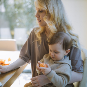 mom working on laptop while holding toddler