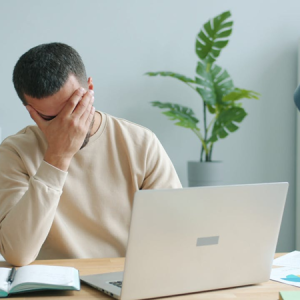 man getting frustrated while working on laptop