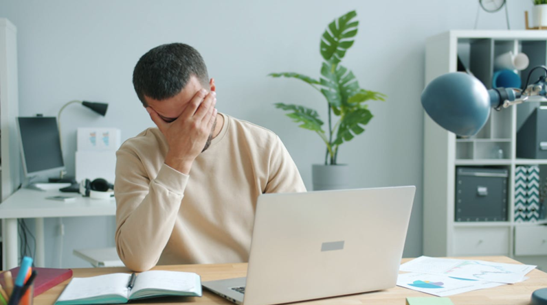 man getting frustrated while working on laptop