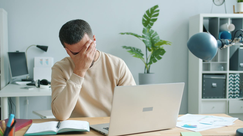 man getting frustrated while working on laptop