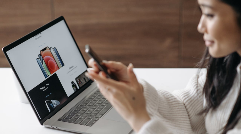 woman using smart phone and laptop at the same time