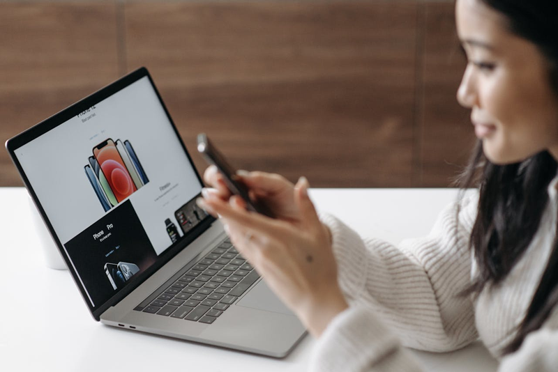 woman using smart phone and laptop at the same time
