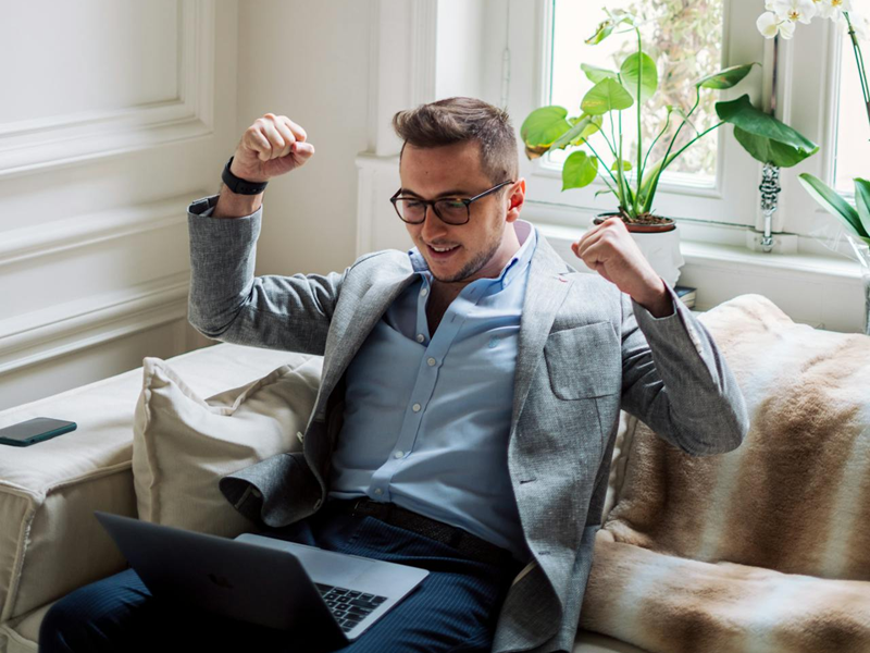 man working on laptop happy with the results he's getting
